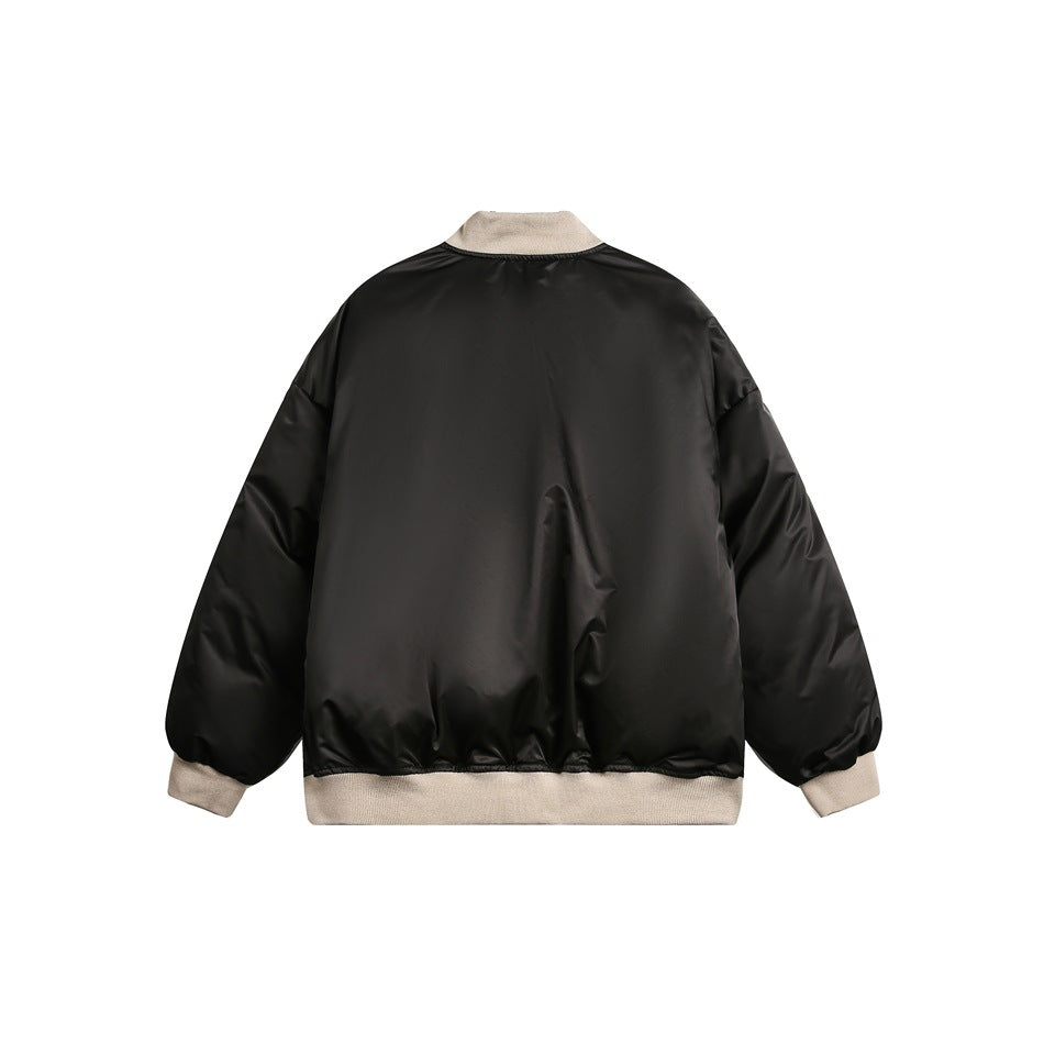 Back view of a black jacket laid flat, with beige ribbed collar, cuffs and hem.