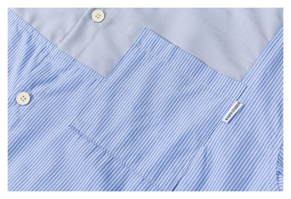 Close-up of a blue-and-white striped shirt with a solid blue pocket, cream buttons, and a small sewn label.