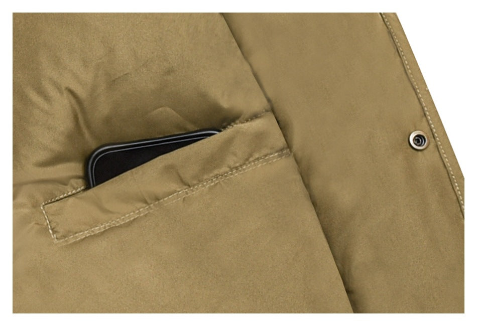 Close-up of a tan jacket pocket with a black phone tucked inside and a metal snap on the front placket.