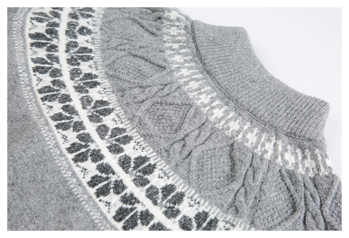 Close-up of a gray knit sweater neckline with cable stitching and a white-and-charcoal geometric pattern.