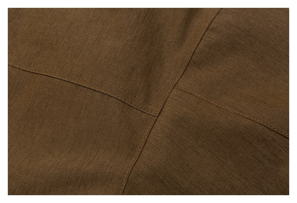 Close-up of stitched panel seams on the brown jacket.