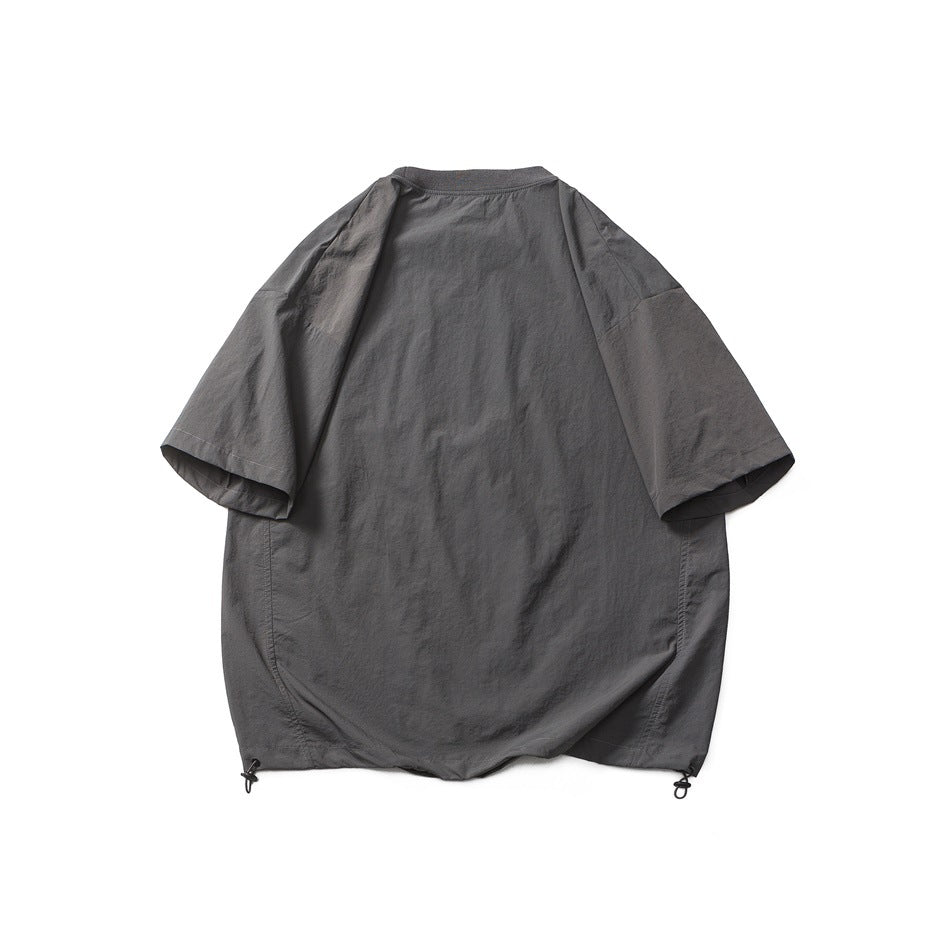 Back view of a loose charcoal gray short-sleeve top with a rounded hem and adjustable hem cords.