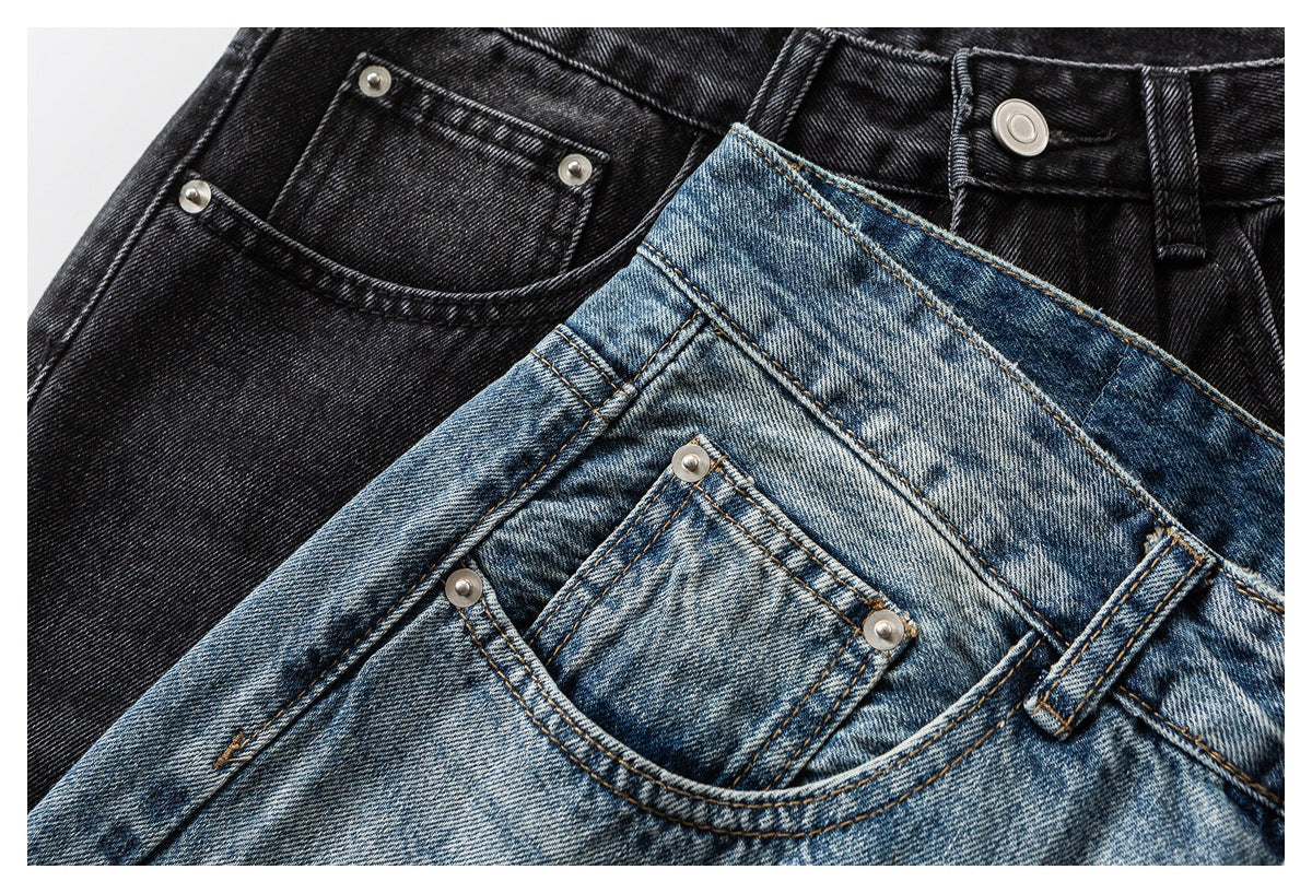 Close-up of black and faded blue jeans showing waistbands, buttons, belt loops and front pockets.