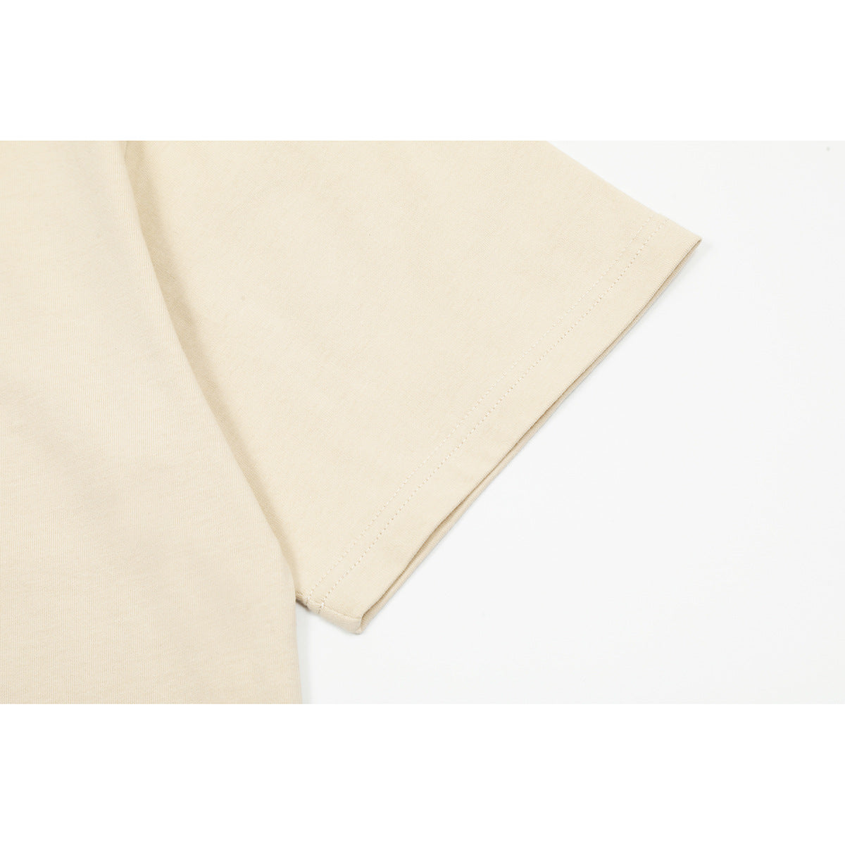 Close-up of the cream T-shirt's short sleeve and double-stitched cuff.