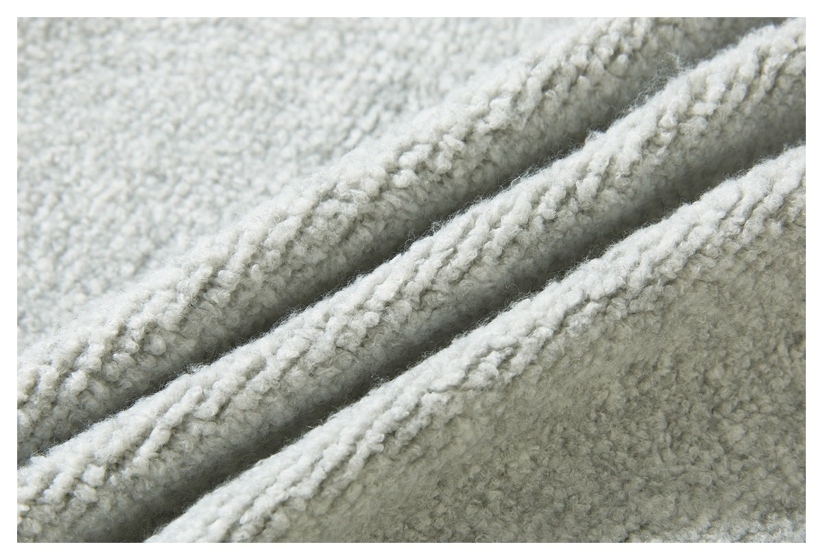 Macro view of the light gray sweater's textured knit, shown in soft folds.