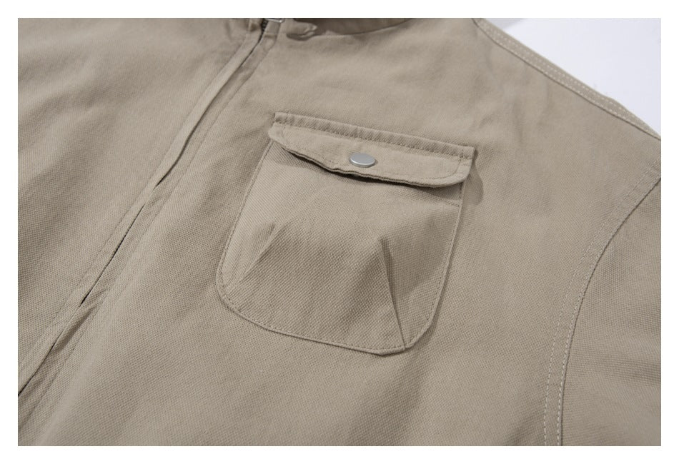 Close-up of a tan jacket’s chest pocket with a snap-fastened flap.