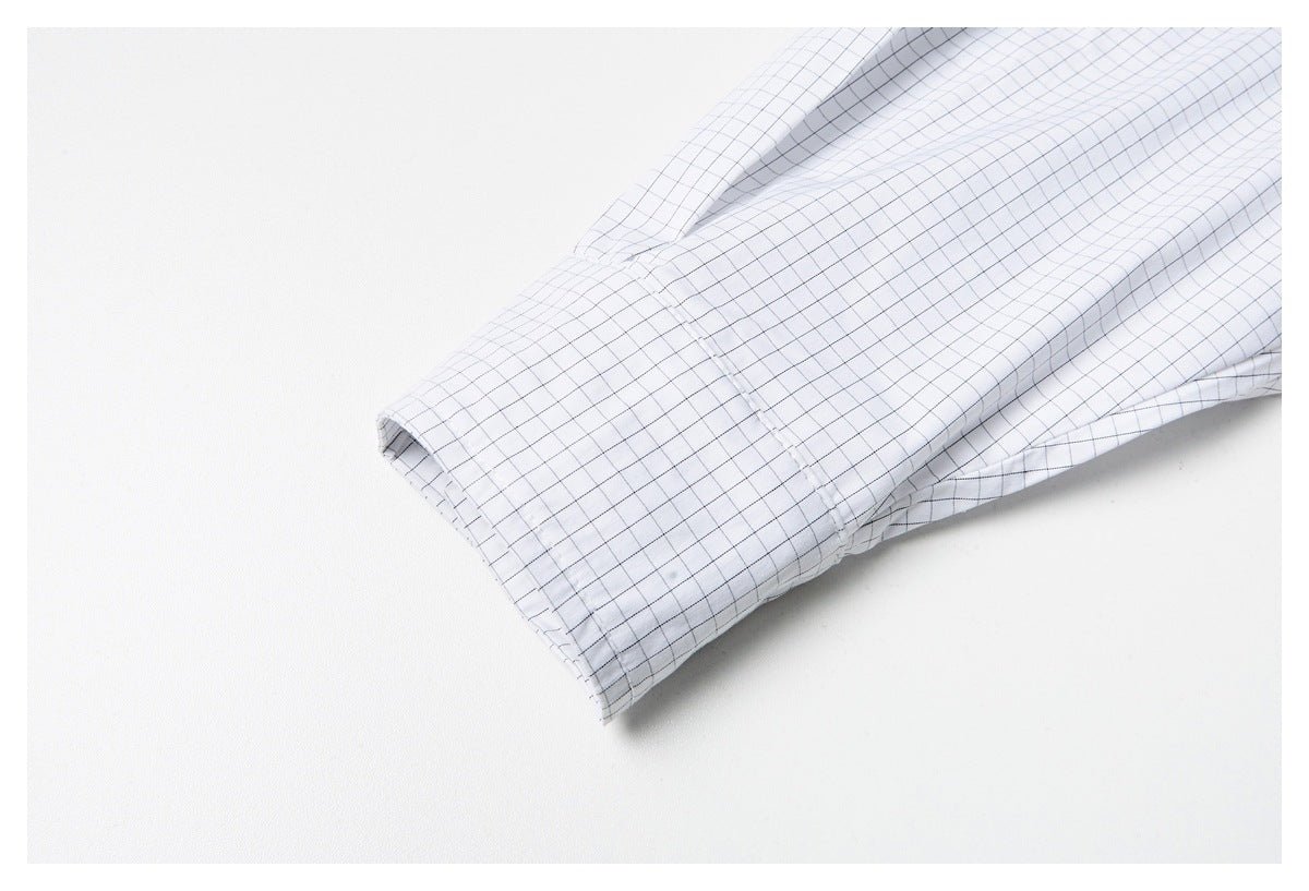 Close-up of the white grid-check shirt's long sleeve and wide button cuff.