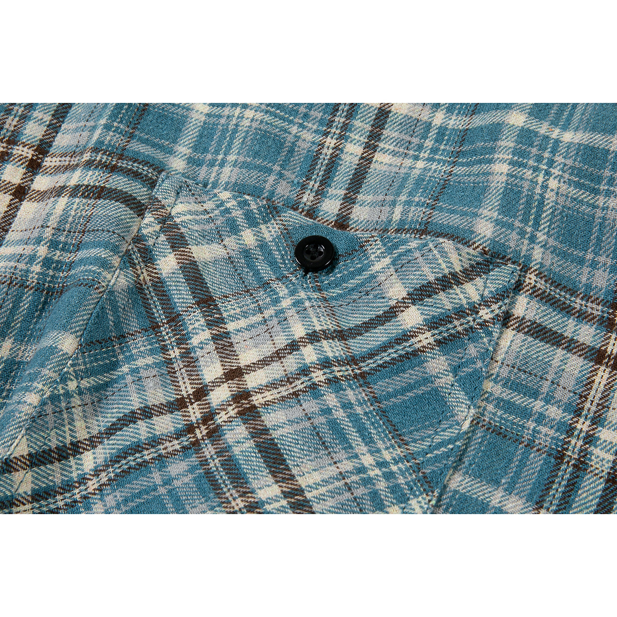 Close-up of a buttoned chest pocket on a blue, cream, and brown plaid shirt.