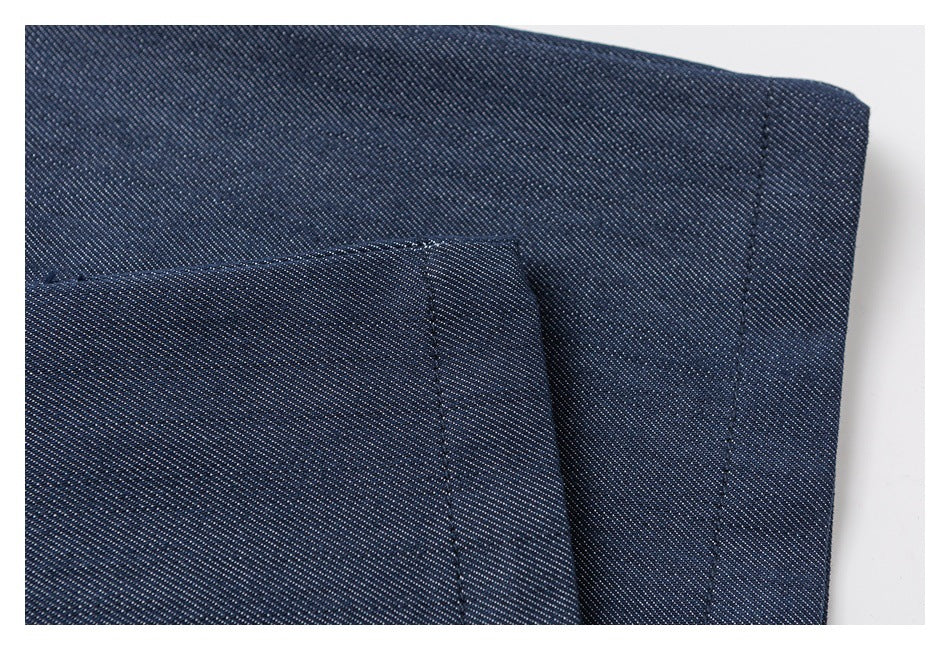 Close-up of navy trouser fabric with a stitched hem and overlapping panel.