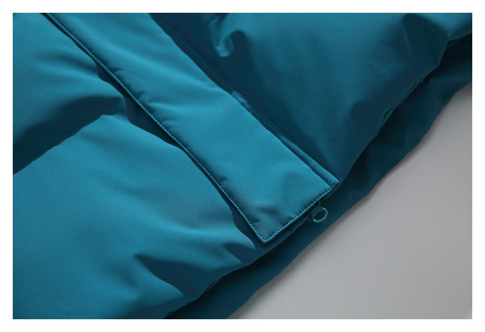 Close-up of a teal jacket hem and overlapping flap with a small snap loop.