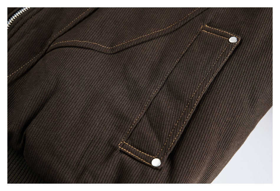 Close-up of a brown jacket's narrow flap pocket with two metal snaps and tan contrast stitching.