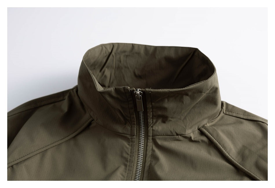 Close-up of an olive jacket's high stand collar, centered zipper, and angled shoulder seams.