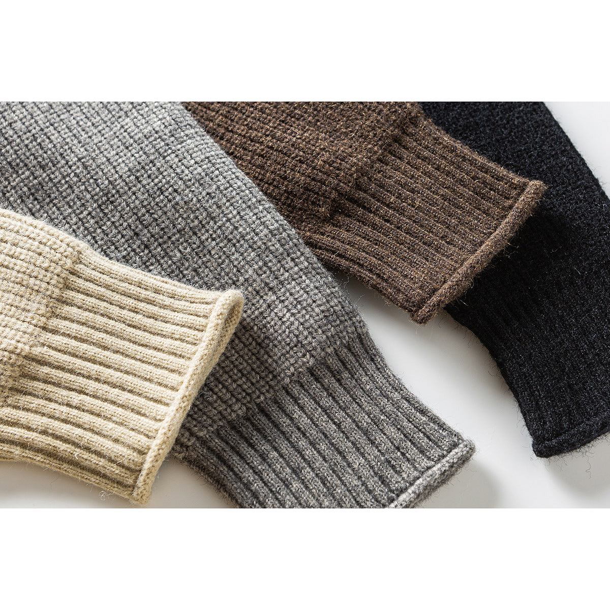 Close-up of rib-knit sweater cuffs in cream, gray, brown, and black.