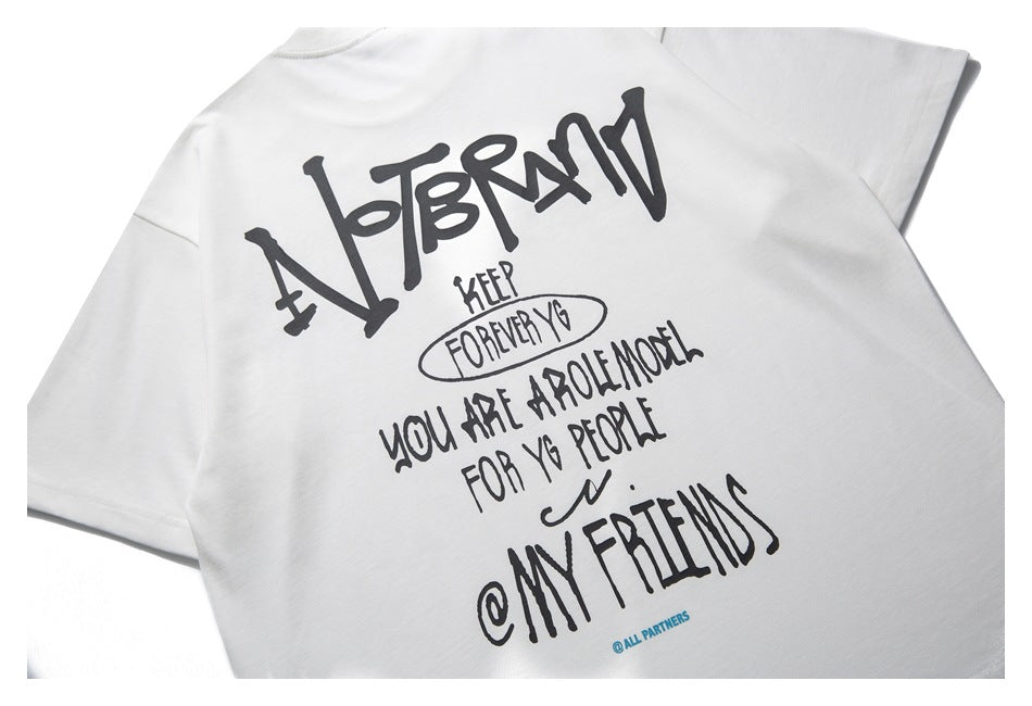 Back view of a white short-sleeve shirt laid flat, with a large black handwritten-style text graphic.