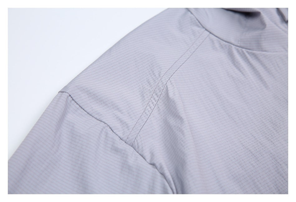 Close-up of the light gray jacket's shoulder and sleeve seams with a fine striped surface.