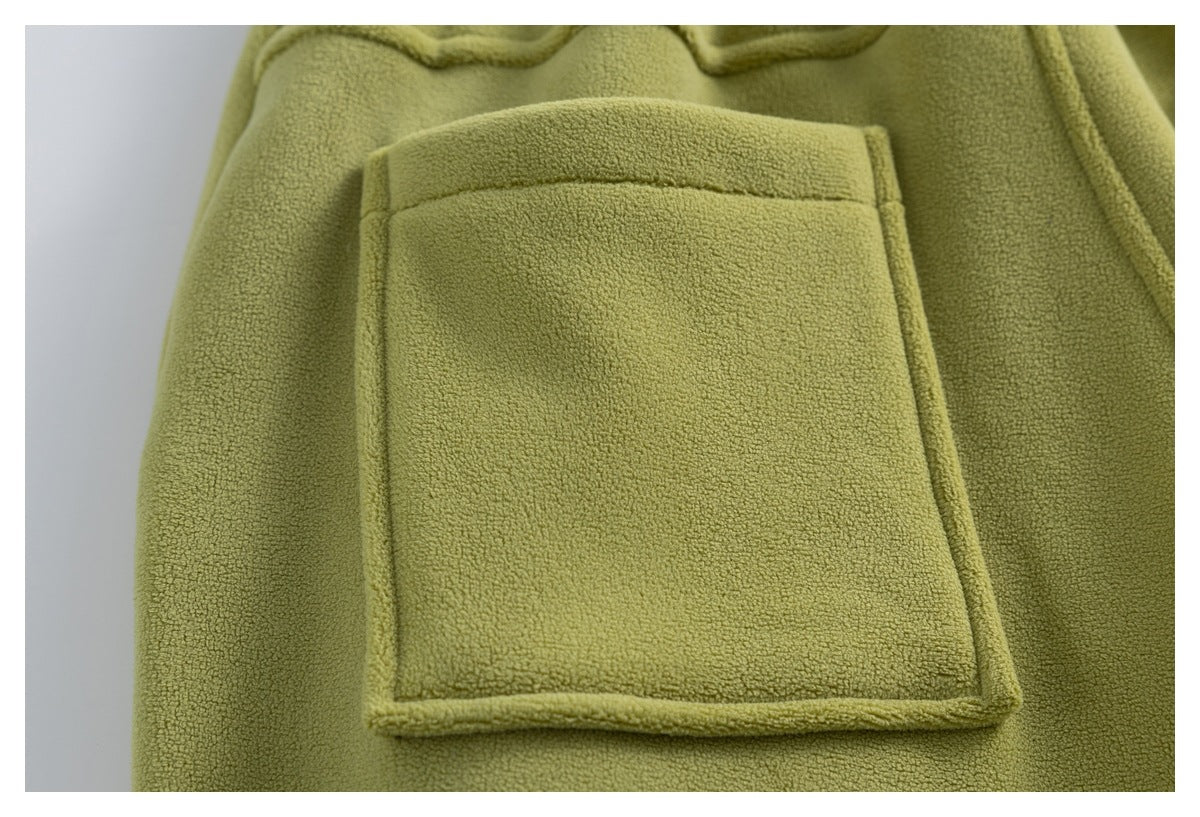 Close-up of one large patch pocket on the back of olive-green fleece pants.