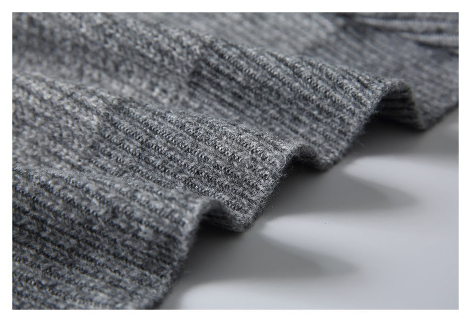 Close-up of the textured gray knit sweater fabric and ribbed edge.
