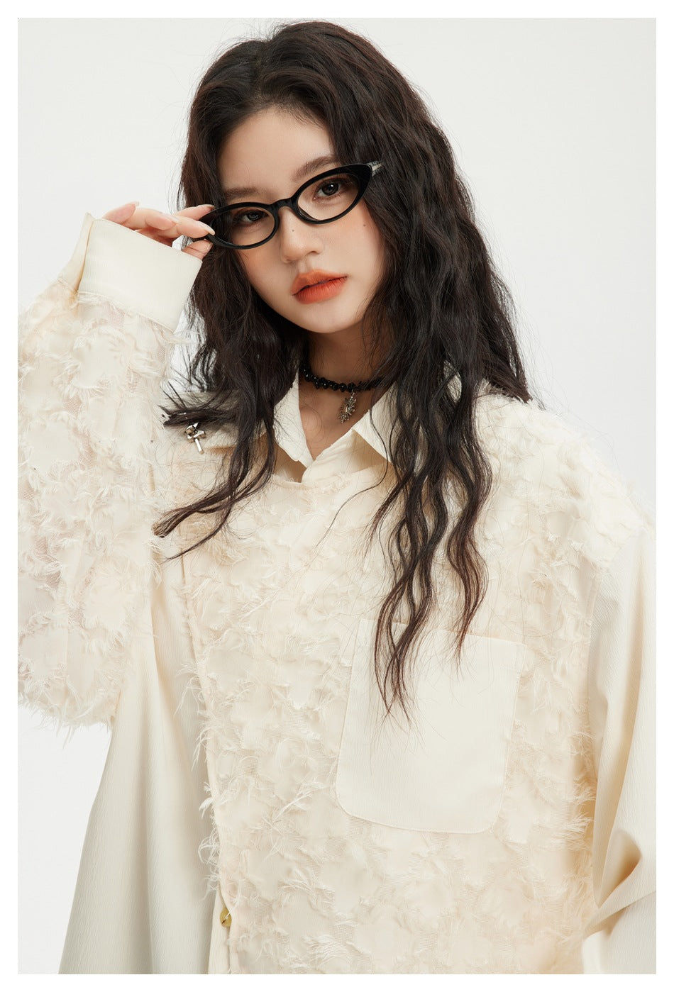 Close-up of a model wearing an ivory textured button-up shirt with a chest pocket and smooth sleeves.