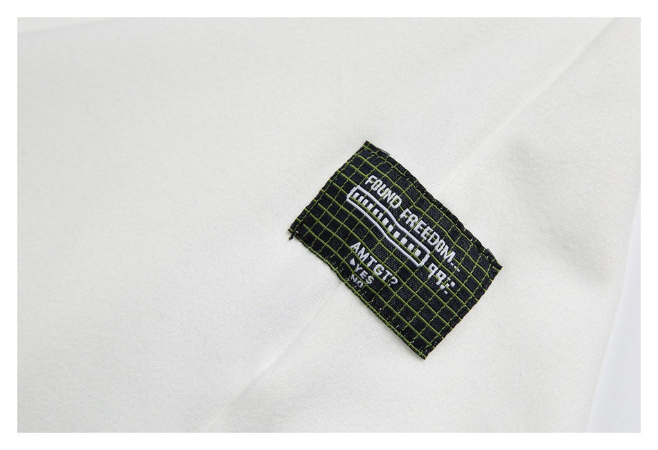 Close-up of a black grid-patterned sewn label on white fabric, with white lettering.