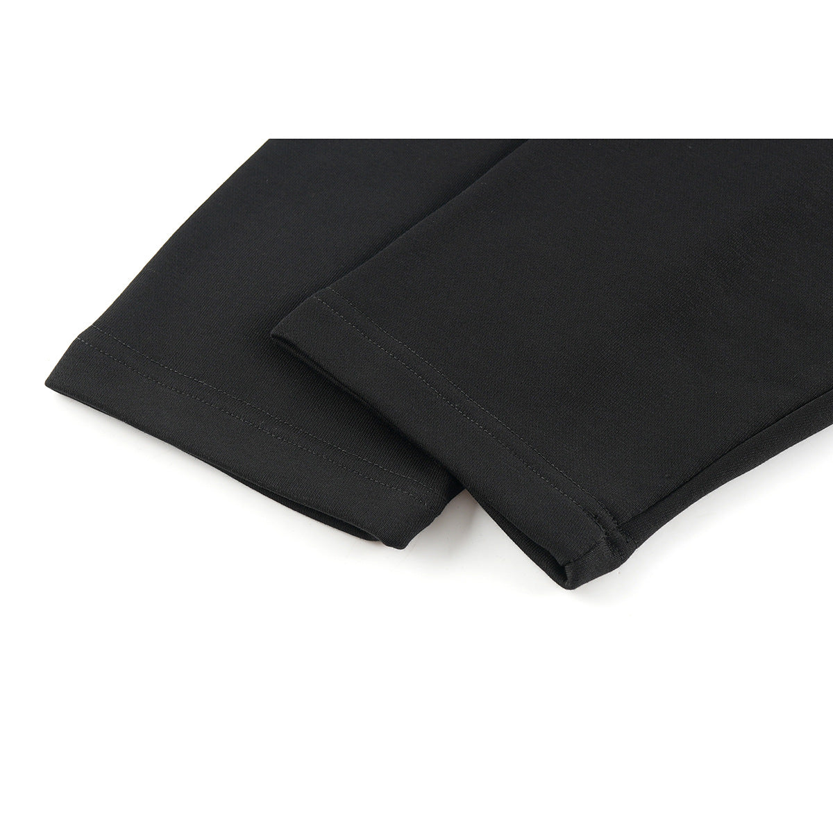 Close-up of the stitched hems of two overlapping black shirt sleeves.