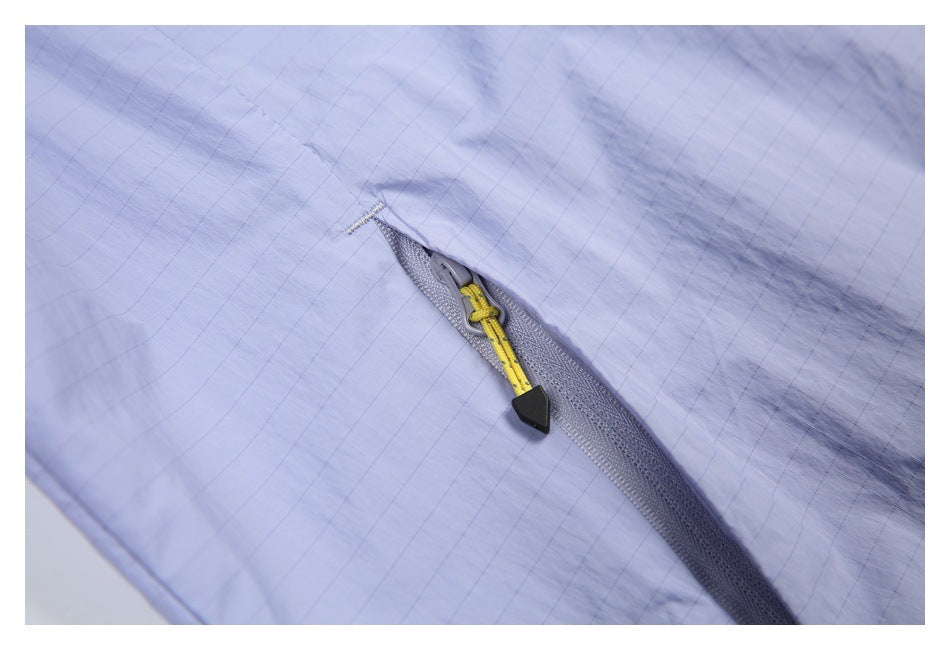 Close-up of a lavender garment with a gray zipper and yellow-and-black pull cord.