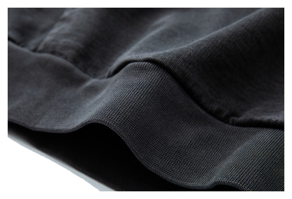 Close-up of the charcoal garment's ribbed hem and knit texture.
