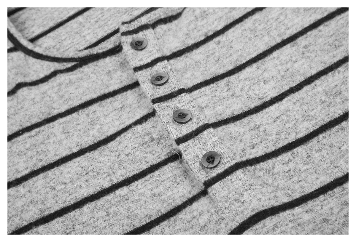 Close-up showing four dark buttons on the placket of a light gray shirt with dark stripes.