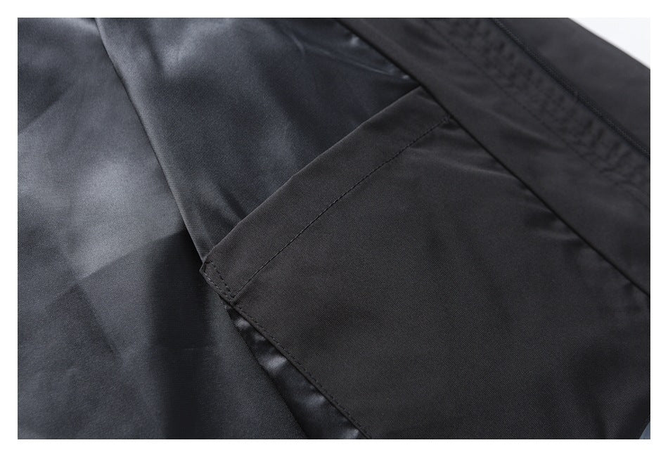 Close-up of a black jacket pocket opening and stitched panel seams.