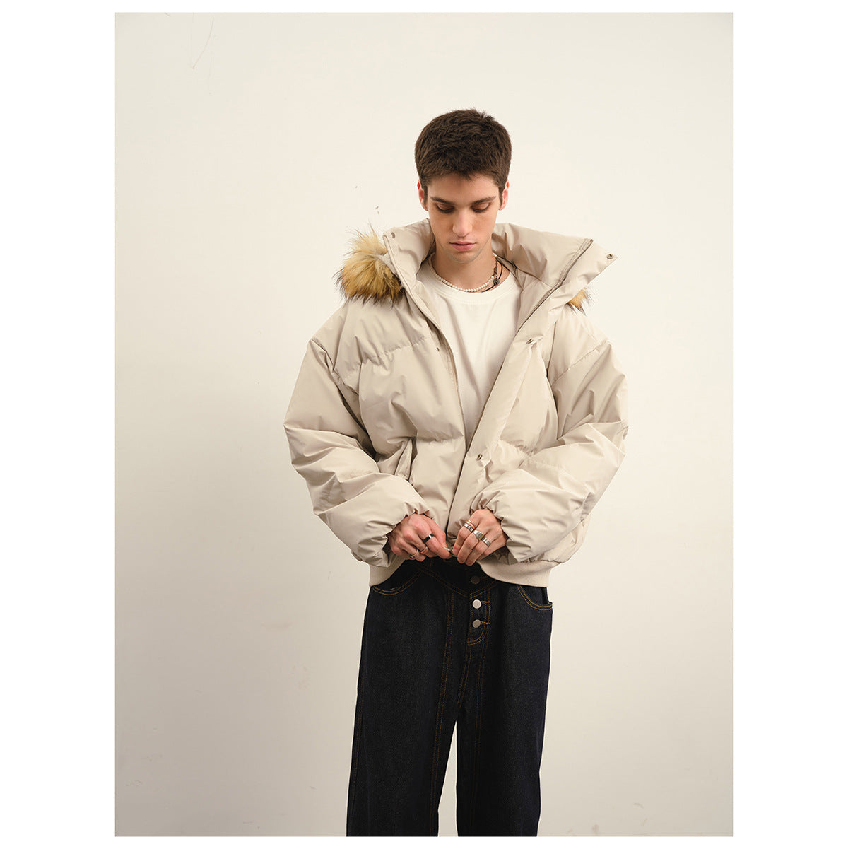 Model wearing a light beige puffer jacket with a tan fur-trimmed hood, shown from the front.