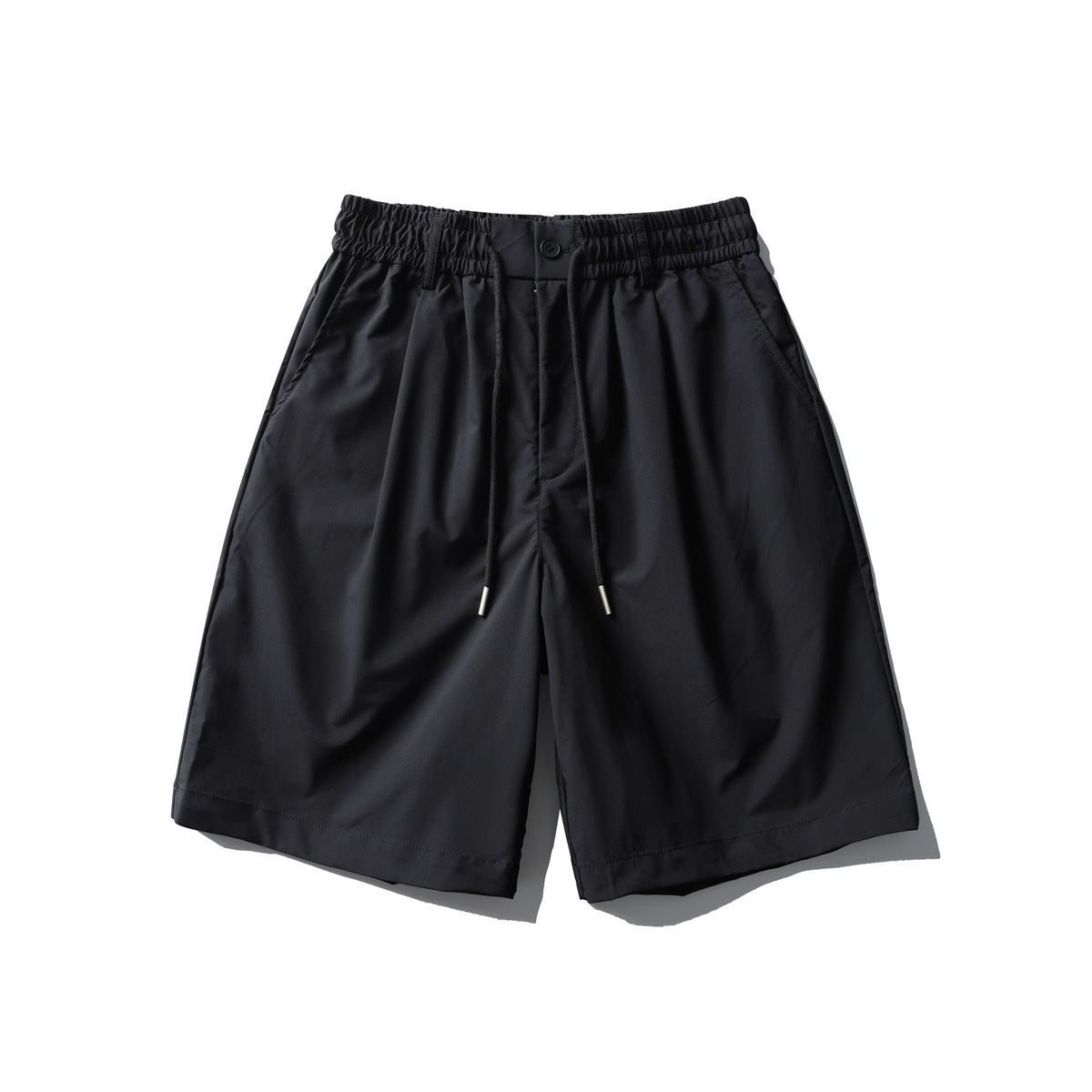 Black knee-length shorts with elastic drawstring waist, button front, pleats and side pockets, flat lay front view