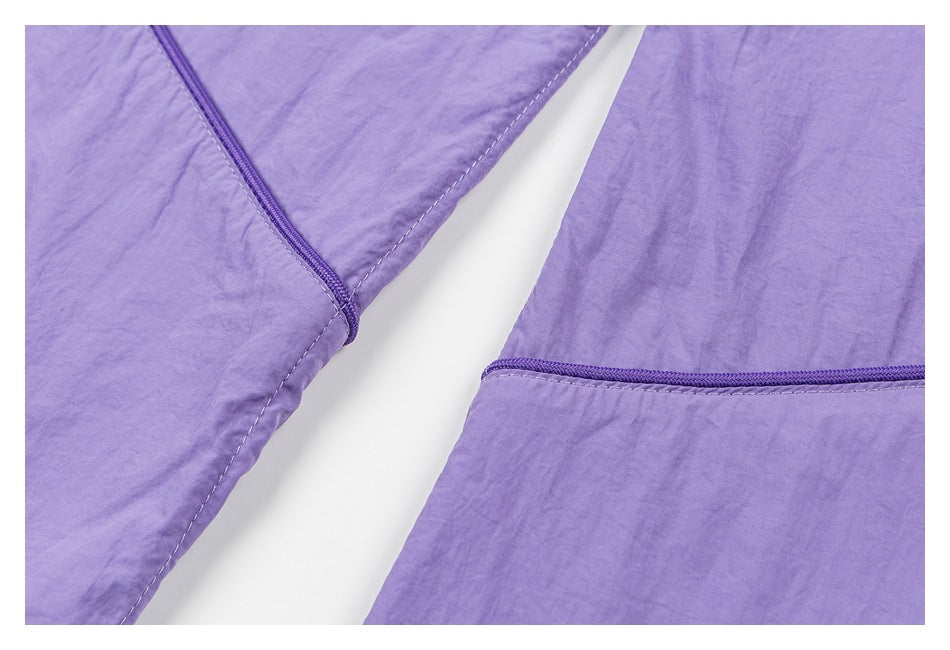 Close-up of lavender garment panels with purple zipper trim and stitched edges.