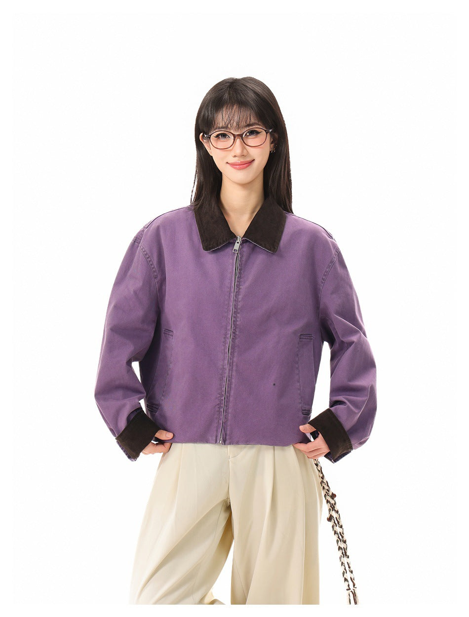 Front view of a model wearing a zipped purple jacket with a dark collar, cuffs and front pockets.