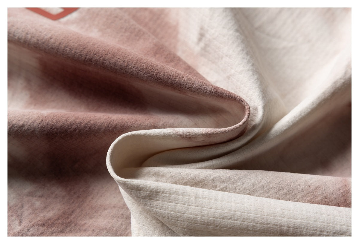 Close-up of the shirt fabric folded to show its cream and dusty-rose pattern and surface texture.