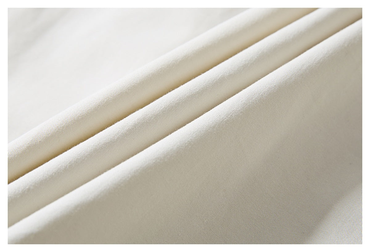 Close-up showing the smooth, fine texture of ivory shirt fabric in soft folds.