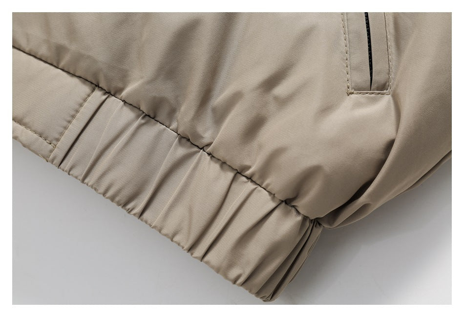 Close-up of the beige jacket's gathered elastic hem and nearby pocket opening.