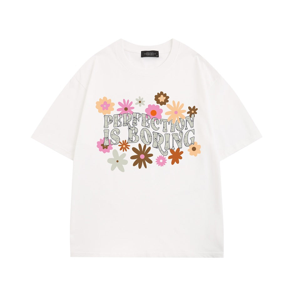 White short-sleeve crew neck T-shirt with colorful retro flowers and 'PERFECTION IS BORING' print
