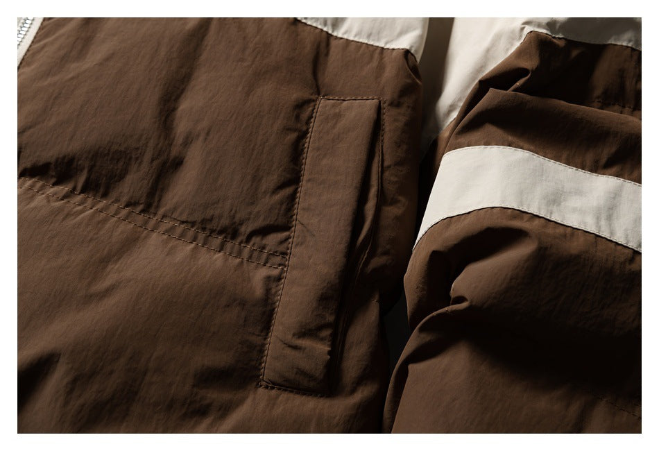 Close-up of a brown jacket pocket and sleeve with a cream horizontal stripe.
