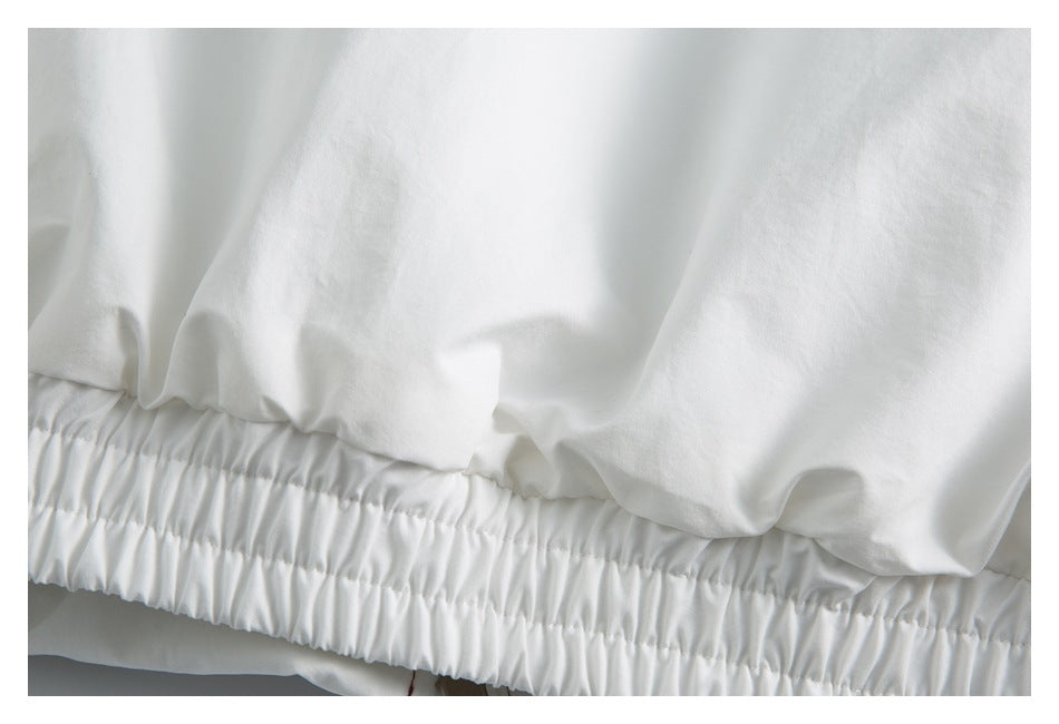 Close-up of a white garment's gathered elastic waistband or hem.
