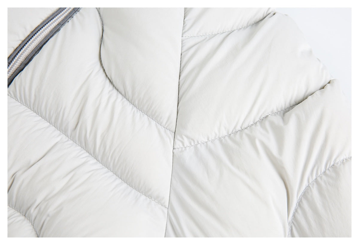 Close-up of the light gray jacket's padded quilting and curved seam lines.