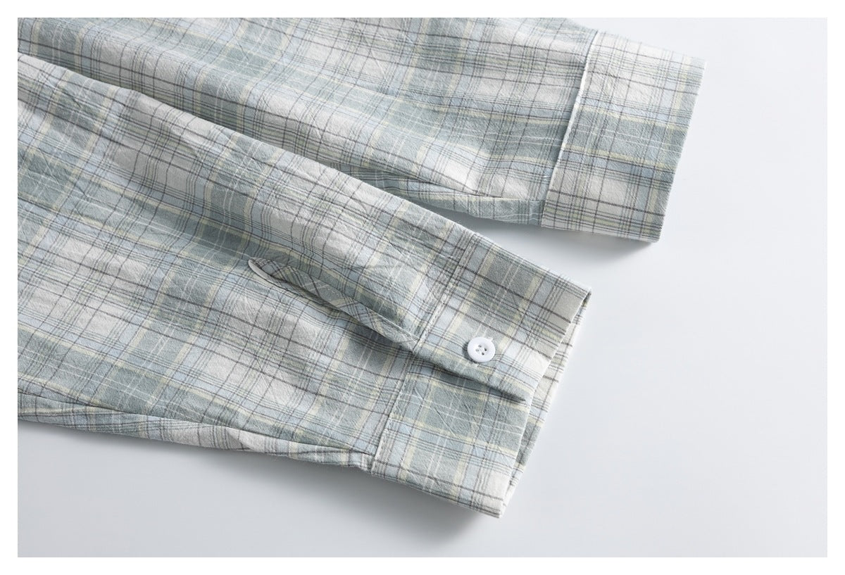 Close-up of two pale blue-gray plaid shirt cuffs with white buttons and visible stitching.