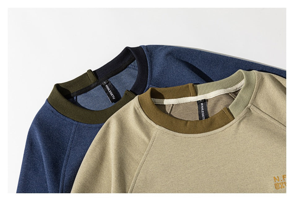 Two overlapping sweatshirts in navy and beige, showing contrasting ribbed collars and partial chest embroidery.