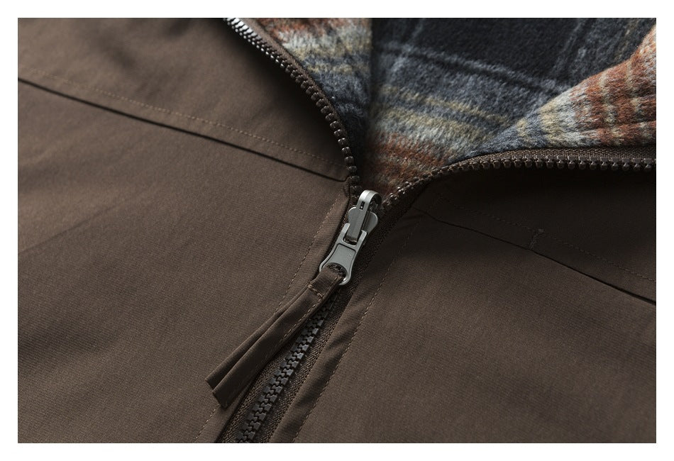 Close-up of a brown garment’s front zipper and multicolored plaid lining.