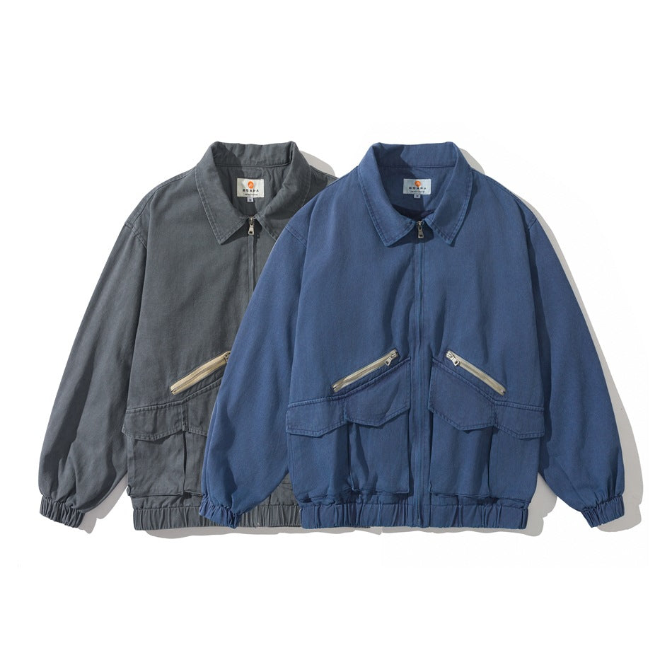 Two front-facing zip jackets, one charcoal gray and one blue, with flap pockets and gathered hems and cuffs.