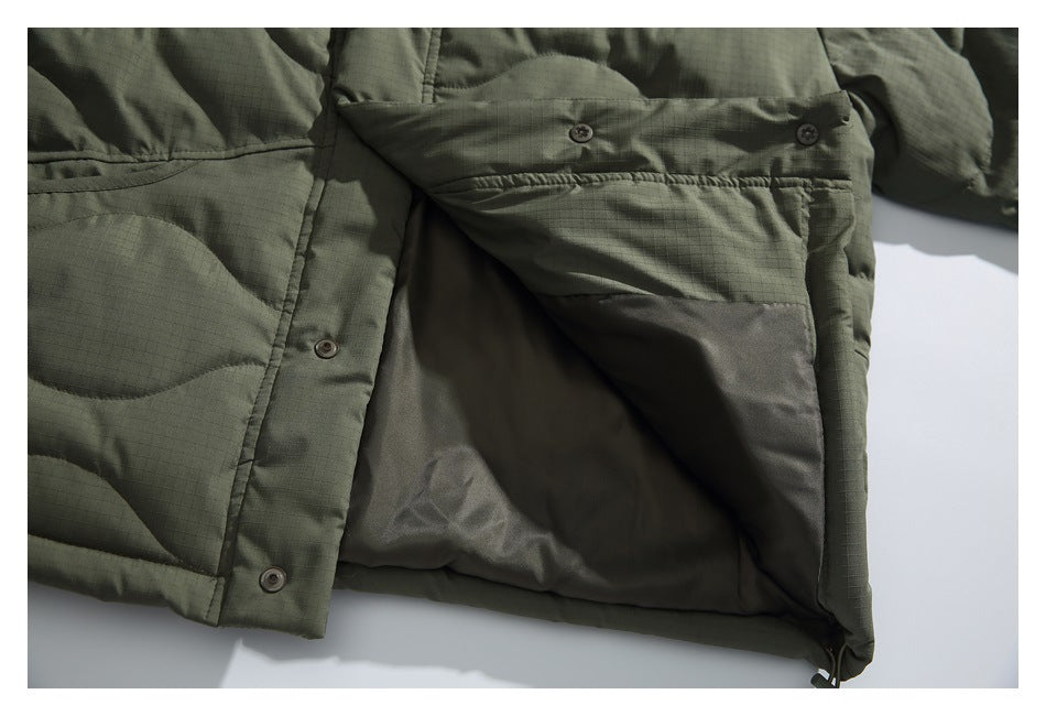 Opened olive quilted jacket showing its smooth dark lining, snap-button placket, and hem.