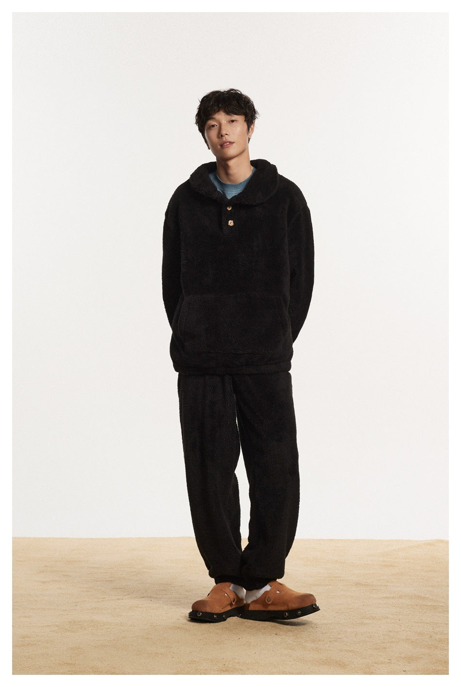 Full-length view of a model in a black plush pullover and matching pants.