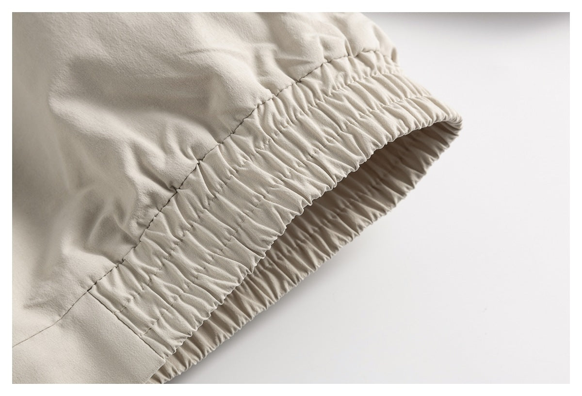 Close-up of a gathered elastic edge on a light beige garment.