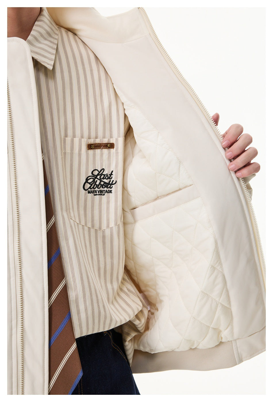 Close-up of the cream jacket's quilted lining and zipper beside a striped shirt with a chest graphic.