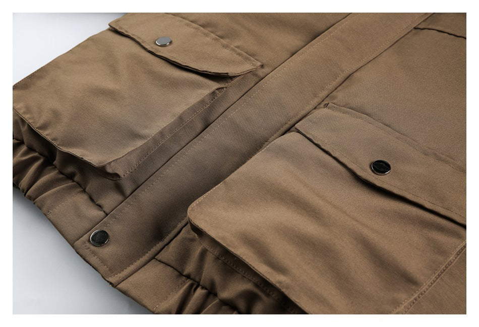 Close-up of the jacket’s brown fabric, large flap pockets and dark snap closures.