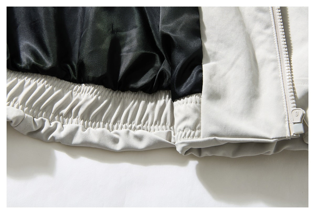 Close-up inside the off-white jacket showing black lining, gathered elastic trim, and zipper hardware.