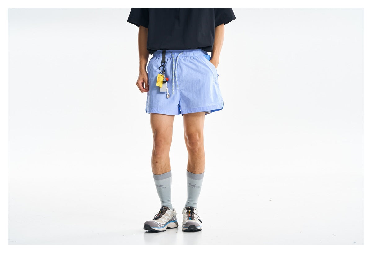 Front view of light blue elastic-waist shorts with a drawcord, worn by a model; the upper body is cropped.